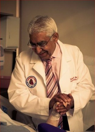 Dr. Gulshan Sethi holding a patient's hand